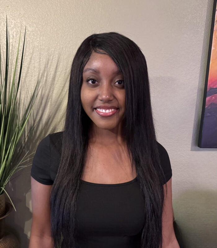 Meet Our Team - Professional and Welcoming Group at a Conference Table Faces the Camera, Team Leader Sitting on the Table with Arms Folded